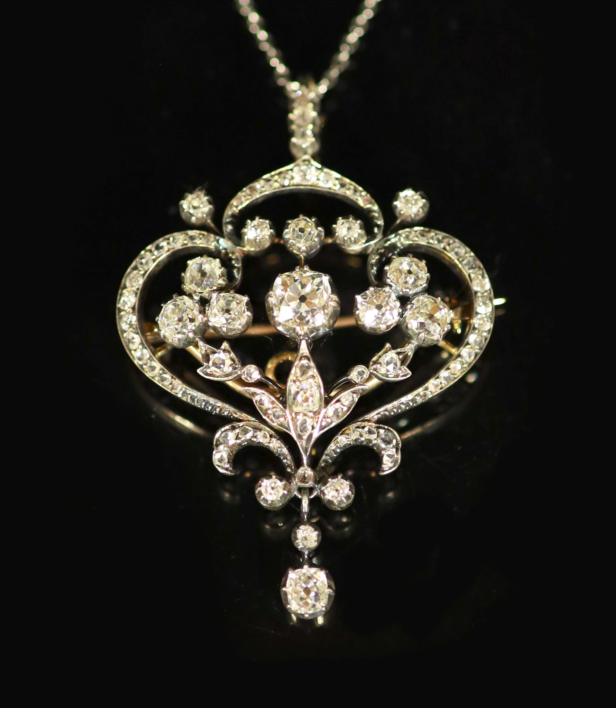 A 19th century gold, silver and diamond set open work scroll drop pendant brooch, together with a white metal chain